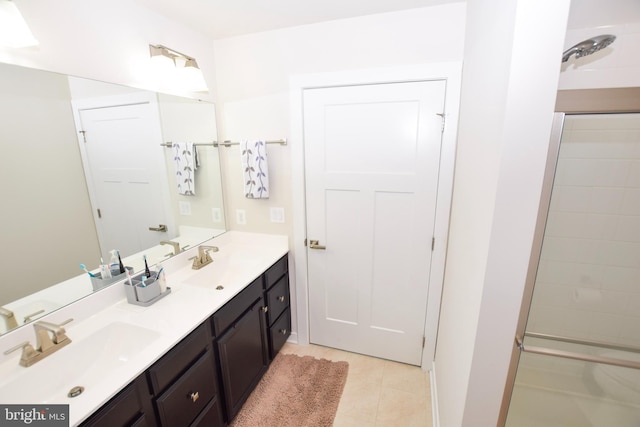 bathroom with double vanity, tile patterned floors, a shower, and a sink