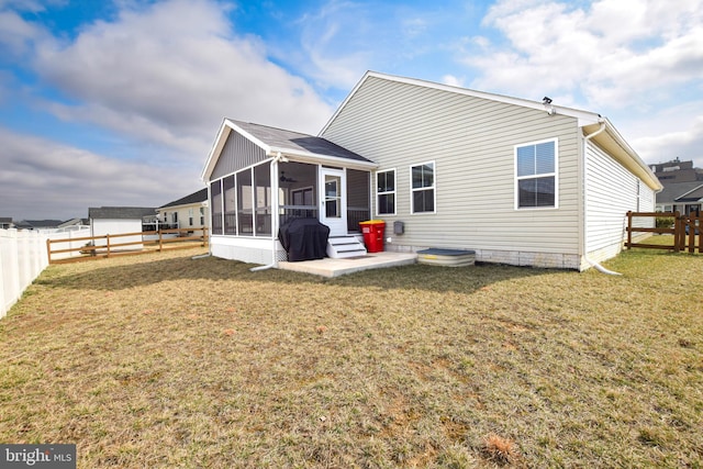 rear view of property with a yard, a fenced backyard, and a sunroom