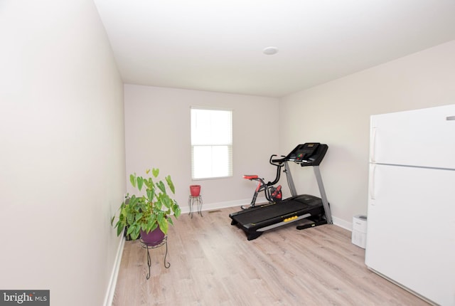 exercise room with baseboards and wood finished floors