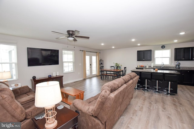 living area with recessed lighting, a ceiling fan, and light wood-style floors