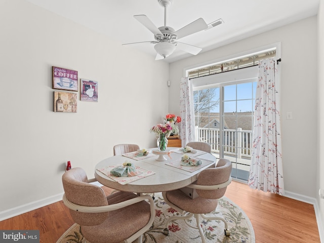 dining area featuring visible vents, baseboards, wood finished floors, and a ceiling fan