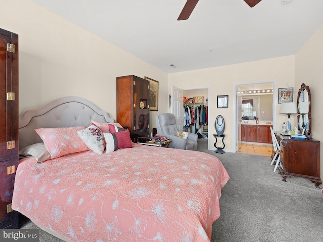 bedroom featuring a spacious closet, ceiling fan, carpet flooring, a closet, and ensuite bath