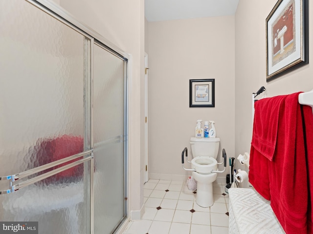 bathroom featuring tile patterned flooring, a shower stall, toilet, and baseboards