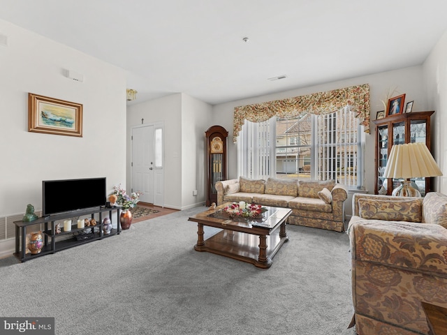 living area with carpet, visible vents, and baseboards