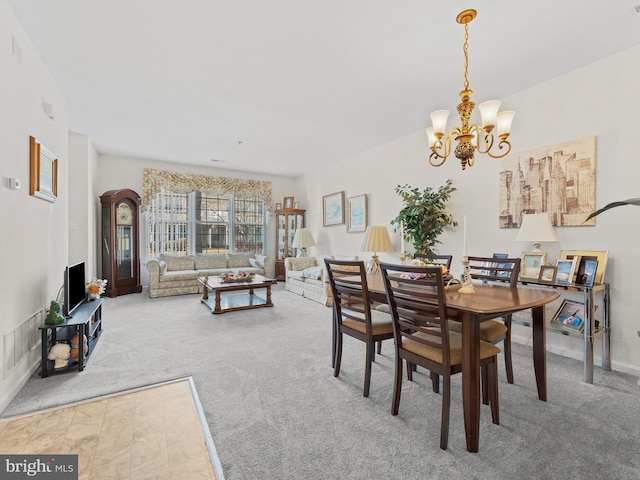 dining space with carpet and an inviting chandelier