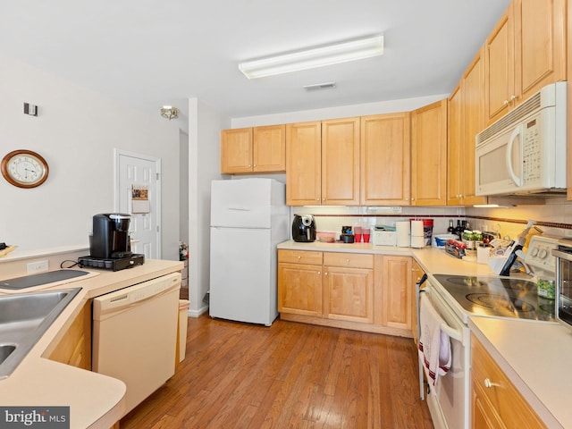 kitchen with white appliances, visible vents, light wood finished floors, light brown cabinetry, and light countertops