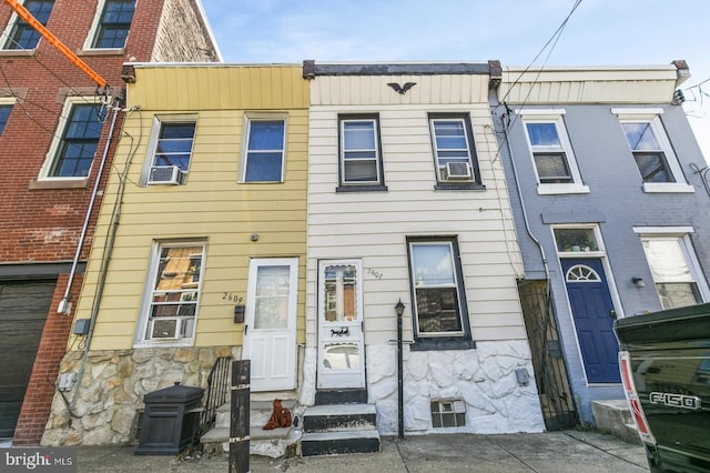 view of property featuring stone siding and cooling unit