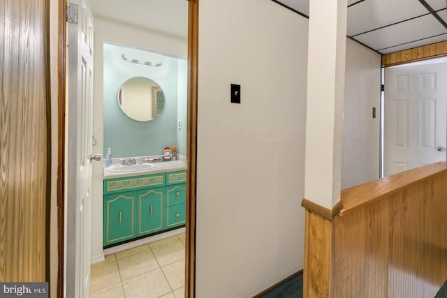 bathroom featuring tile patterned flooring, vanity, and a paneled ceiling