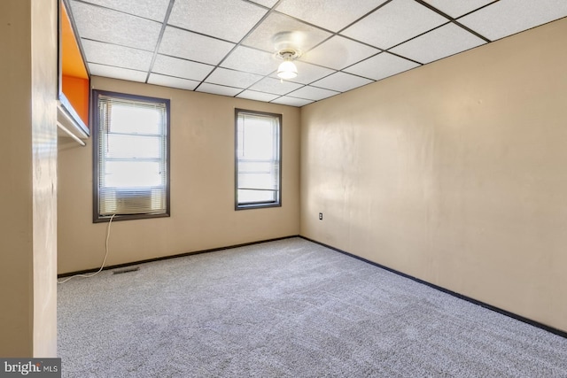 unfurnished room featuring visible vents, a paneled ceiling, and carpet