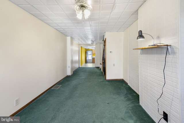 corridor with dark colored carpet, visible vents, and baseboards