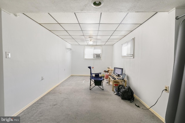 interior space with a drop ceiling and baseboards