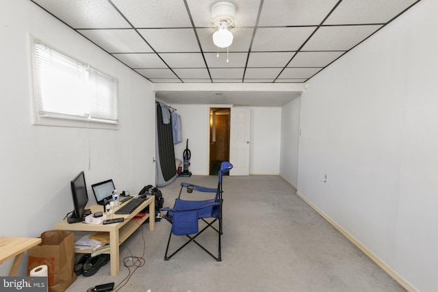 exercise room featuring baseboards, a paneled ceiling, and carpet