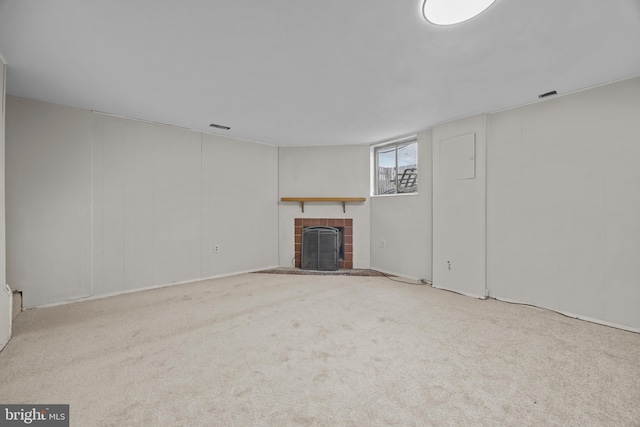 unfurnished living room with a fireplace and carpet