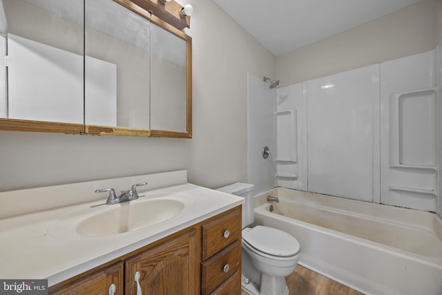 full bath featuring shower / bath combination, toilet, wood finished floors, and vanity