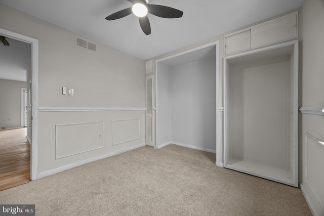 unfurnished bedroom with a closet, visible vents, ceiling fan, and carpet floors