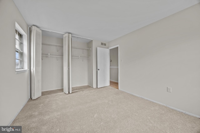 unfurnished bedroom with visible vents, two closets, and carpet flooring