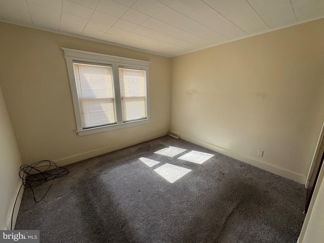 spare room with baseboards and carpet floors