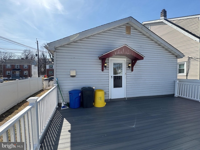 rear view of house with a wooden deck and fence