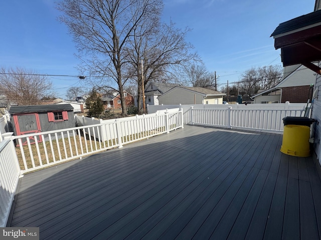 wooden terrace with a residential view, an outdoor structure, and fence