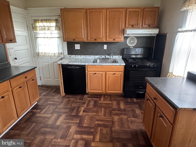 kitchen featuring backsplash, ventilation hood, brown cabinetry, black appliances, and a sink