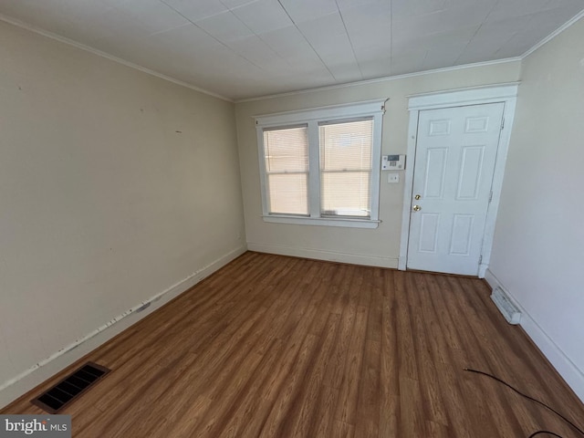 entrance foyer featuring crown molding, wood finished floors, visible vents, and baseboards