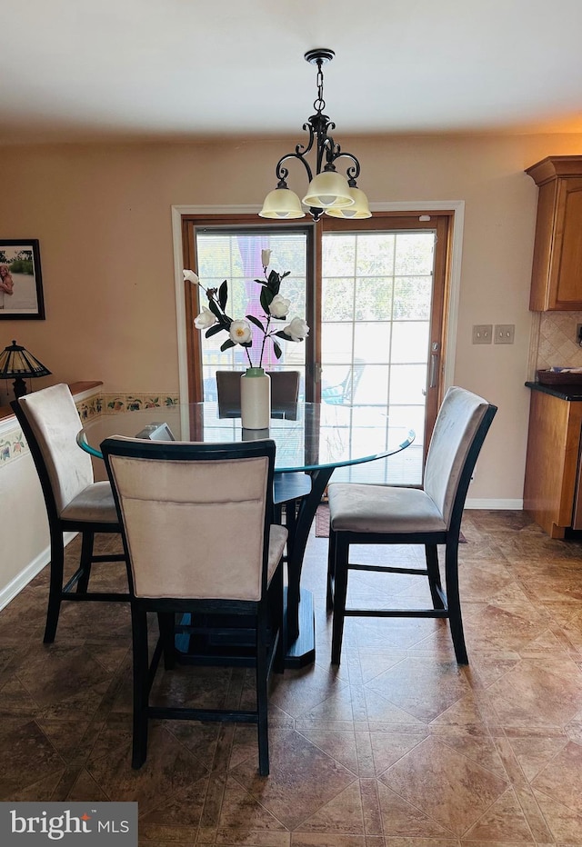 dining space featuring an inviting chandelier and baseboards