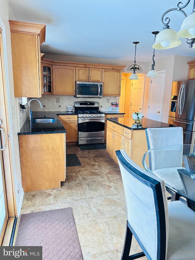 kitchen with backsplash, a center island, glass insert cabinets, stainless steel appliances, and a sink