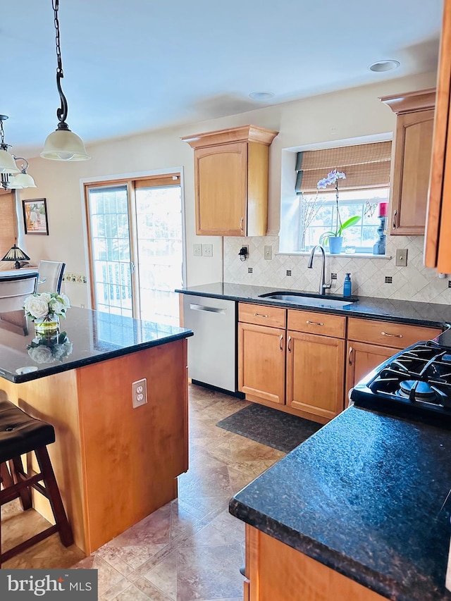 kitchen featuring pendant lighting, a breakfast bar, decorative backsplash, stainless steel dishwasher, and a sink