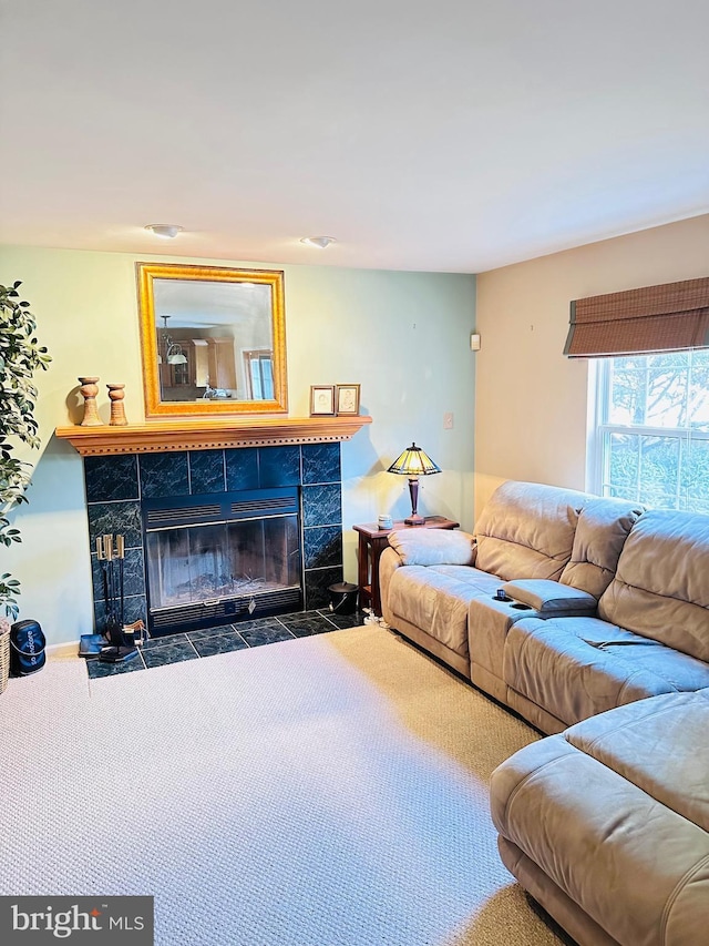 carpeted living room featuring a tile fireplace