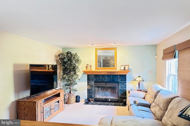 carpeted living room featuring a tile fireplace