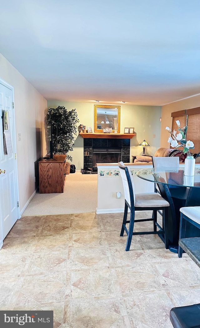 interior space with baseboards and a tile fireplace