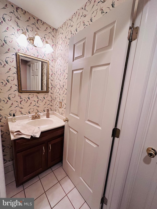 bathroom with vanity, tile patterned flooring, and wallpapered walls