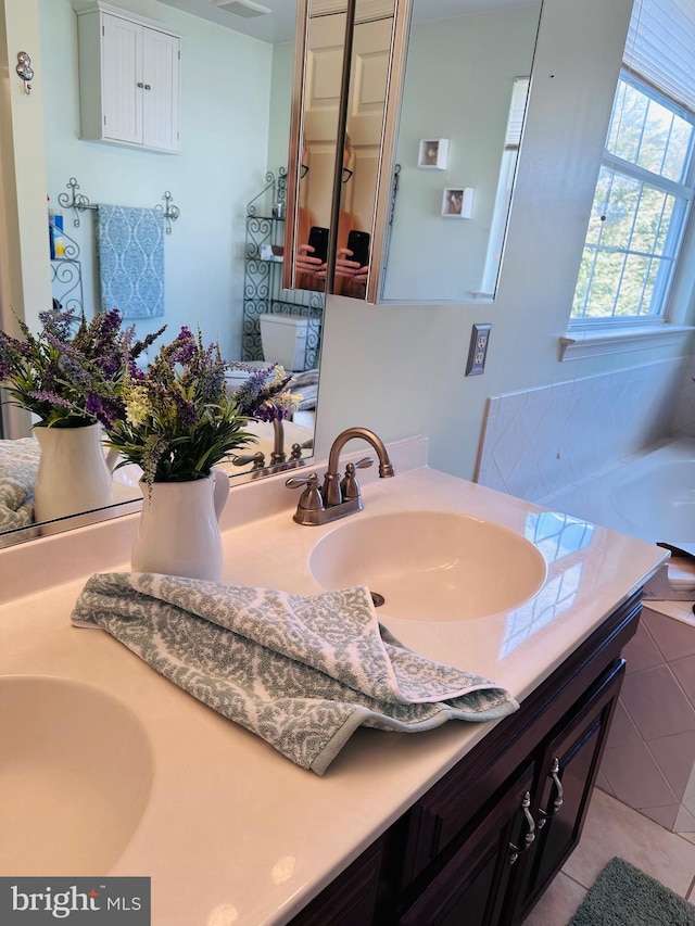 bathroom with a sink, visible vents, and double vanity