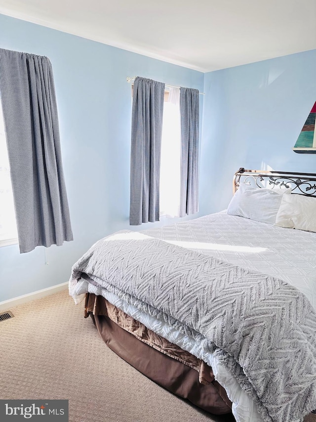 bedroom with baseboards, carpet floors, and visible vents