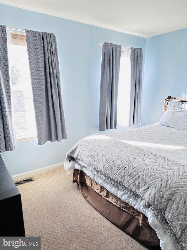 bedroom featuring carpet, visible vents, and baseboards