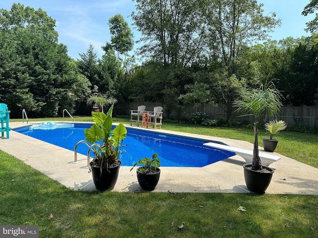 view of pool with a patio, a lawn, and a fenced backyard