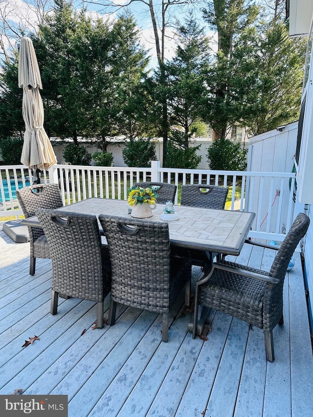 wooden deck featuring outdoor dining area and fence