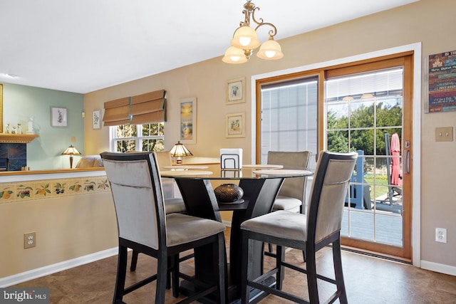 dining space featuring baseboards and a chandelier