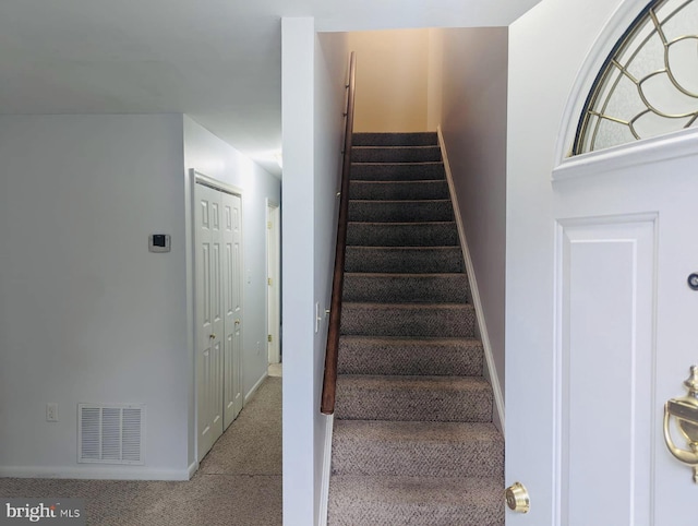 staircase featuring visible vents, baseboards, and carpet