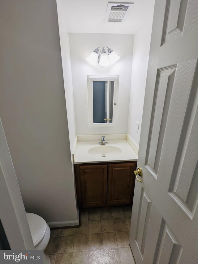 half bathroom with vanity, toilet, and visible vents