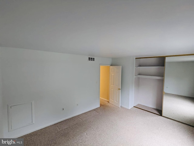 unfurnished bedroom featuring a closet, visible vents, and carpet floors