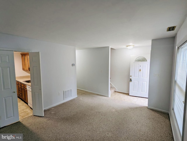 interior space with light carpet, visible vents, and stairs