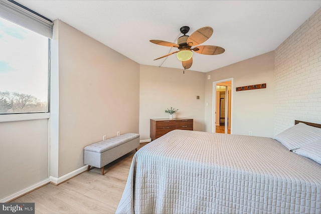 bedroom featuring multiple windows, light wood-style flooring, baseboards, and ceiling fan