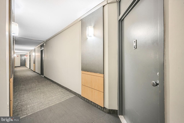 corridor with baseboards and carpet