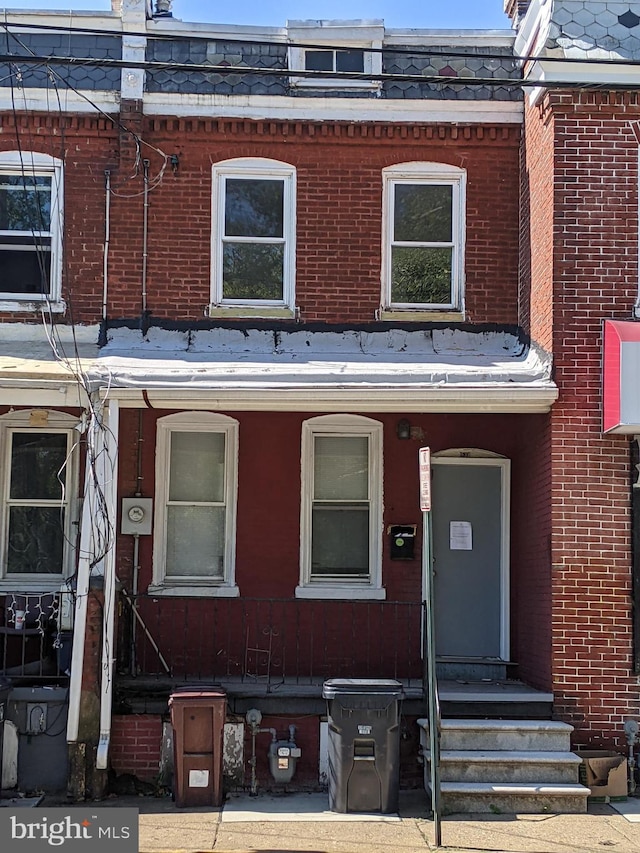 multi unit property featuring mansard roof and brick siding