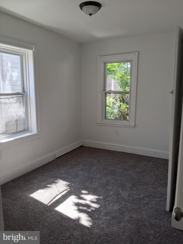 empty room featuring baseboards and carpet