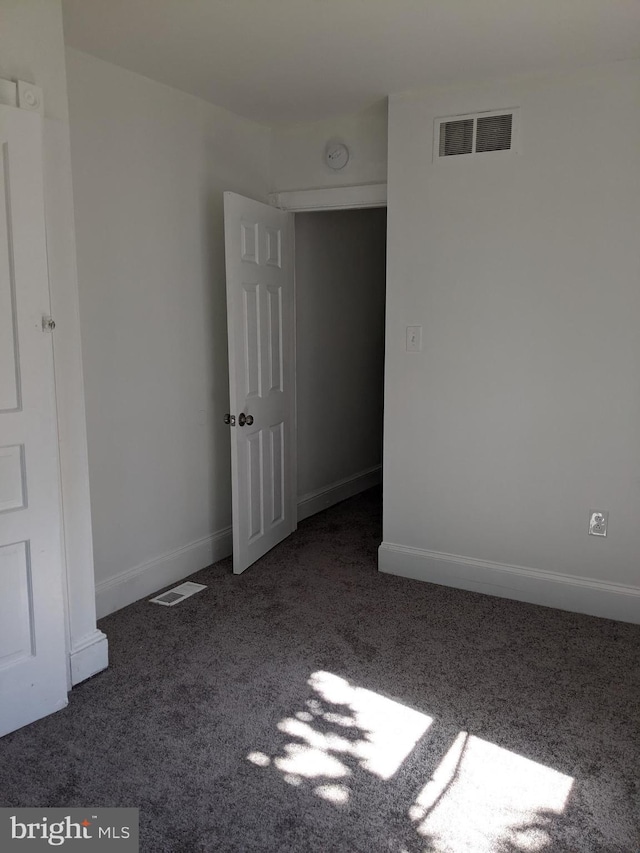 unfurnished room with carpet flooring, baseboards, and visible vents