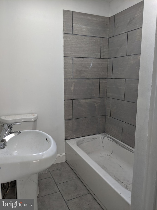 bathroom featuring tile patterned floors, baseboards, a shower, and a washtub