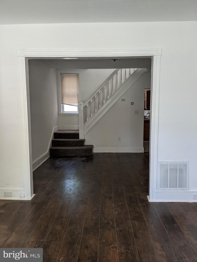 interior space with baseboards, visible vents, and wood-type flooring