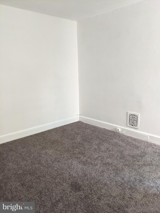 empty room with visible vents, carpet floors, and baseboards